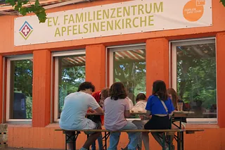 Kinder die vor dem Familienzentrum Apfelsinenkirche sitzen und basteln